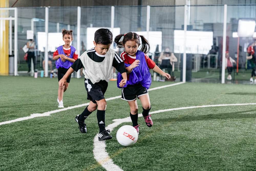 Kids playing soccer on an indoor field